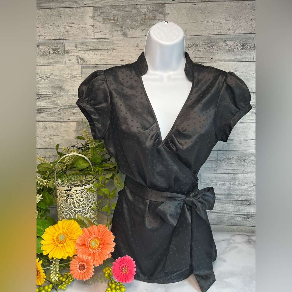 Express black silky wrap around blouse. Ties inform sash or bow. Size small